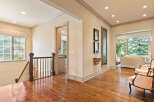 Step into this elegant home featuring a grand staircase and gleaming hardwood floors that lead to an open-concept living area.