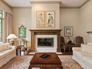 Step into this elegant living room, featuring a grand fireplace as the focal point, flanked by two exquisite Japanese-inspired artworks.