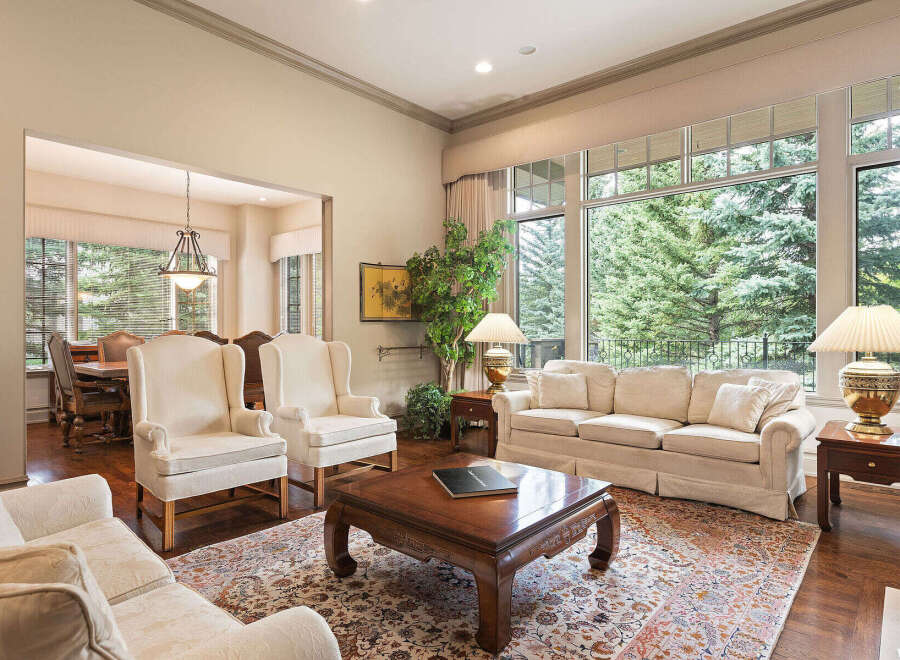 Step into this elegant living room, featuring plush cream-colored seating and a large, ornate coffee table perfect for gatherings.