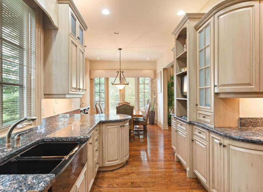 Experience the epitome of culinary luxury in this stunning kitchen, featuring custom light wood cabinetry and exquisite granite countertops.