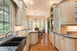 Experience the epitome of culinary luxury in this stunning kitchen, featuring custom light wood cabinetry and exquisite granite countertops.
