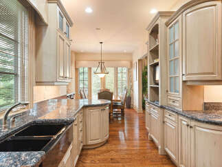Experience the epitome of culinary luxury in this stunning kitchen, featuring custom light wood cabinetry and exquisite granite countertops.