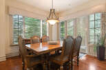 This elegant dining room features a large wooden table surrounded by plush leather chairs, perfect for hosting memorable meals.