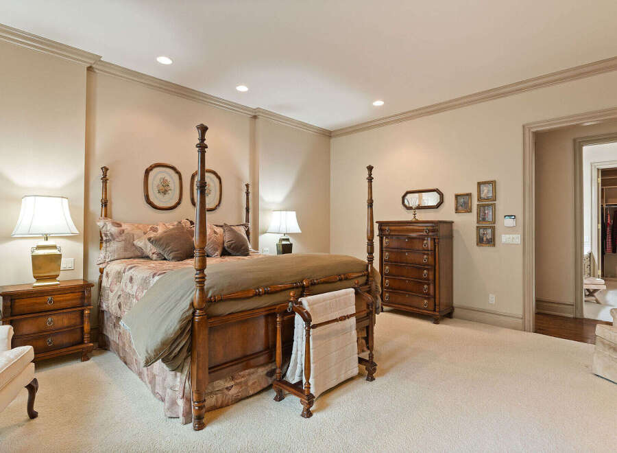 Step into this luxurious master suite, featuring a grand four-poster bed as the centerpiece.