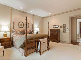 Step into this luxurious master suite, featuring a grand four-poster bed as the centerpiece.