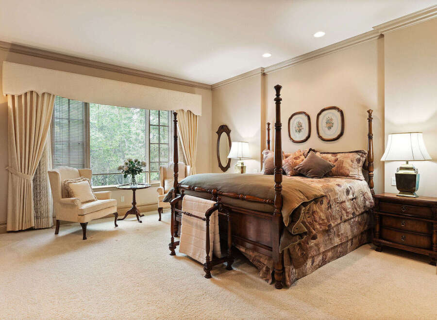 Experience luxurious comfort in this elegant bedroom, featuring a grand four-poster bed adorned with plush bedding and decorative pillows.