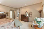 This elegant bedroom features a luxurious four-poster bed with a patterned comforter and a neutral throw.