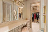 Step into this elegant dressing room, featuring a spacious vanity with ample storage and a plush stool, perfect for your morning routine.