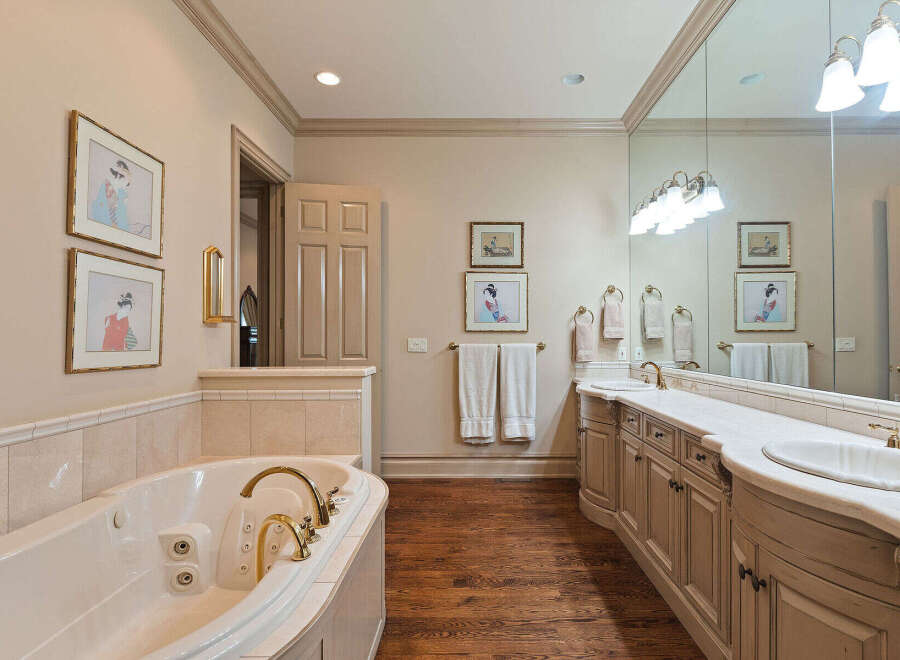 Indulge in luxury with this stunning bathroom featuring a spacious jacuzzi tub and a double vanity with ample counter space.