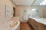 Indulge in luxury with this stunning bathroom featuring a spacious jacuzzi tub and a double vanity with ample counter space.