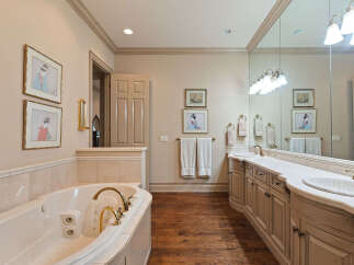 Indulge in luxury with this stunning bathroom featuring a spacious jacuzzi tub and a double vanity with ample counter space.