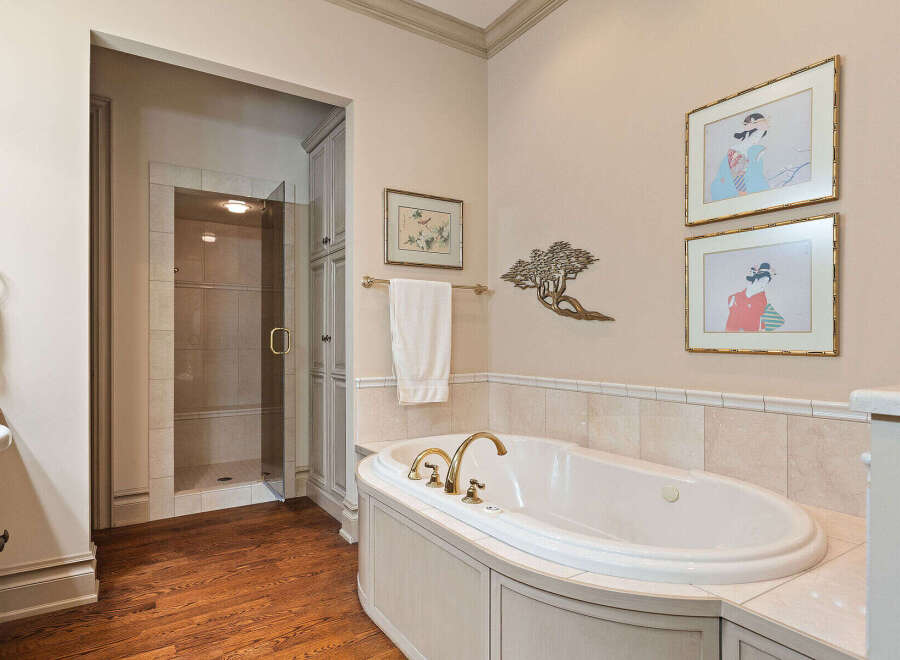 Indulge in luxury in this elegant bathroom featuring a spacious soaking tub with elegant gold fixtures.