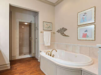 Indulge in luxury in this elegant bathroom featuring a spacious soaking tub with elegant gold fixtures.