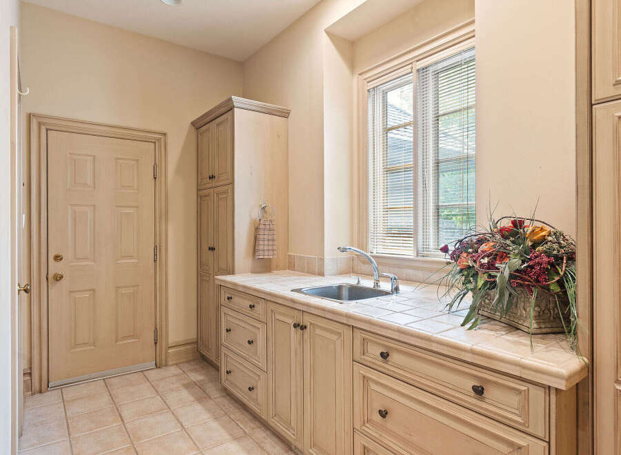 This laundry room features a spacious countertop with a built-in sink, perfect for household chores.