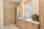 This laundry room features a spacious countertop with a built-in sink, perfect for household chores.