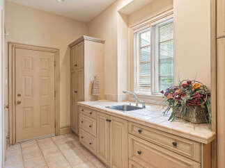 This laundry room features a spacious countertop with a built-in sink, perfect for household chores.
