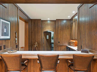 Step into this beautifully appointed home bar, featuring rich wood paneling and a spacious counter perfect for entertaining.
