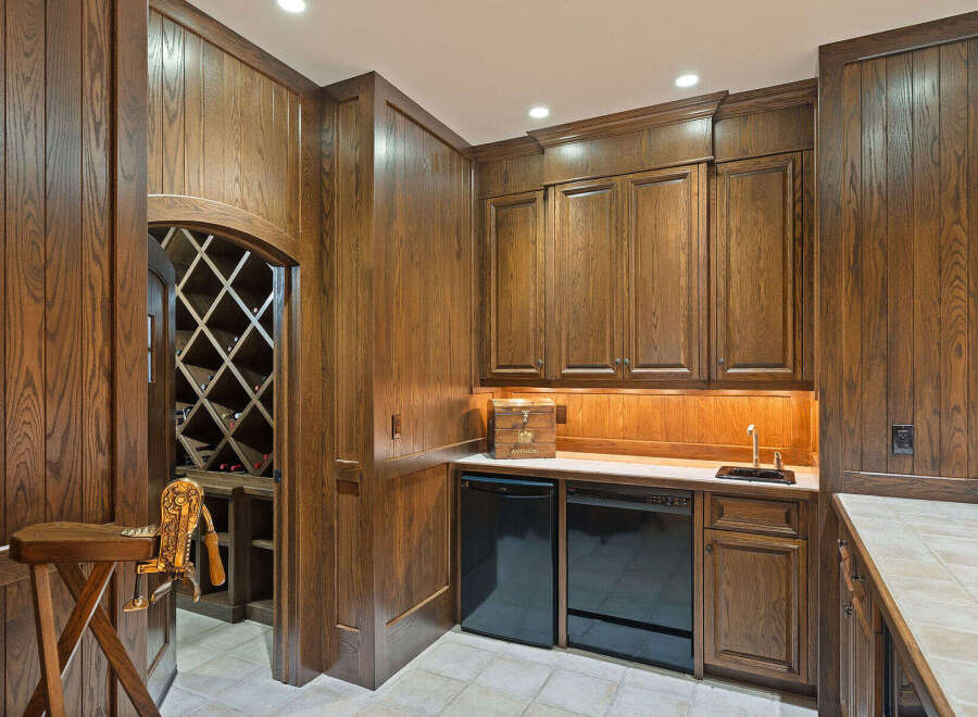 Discover this exquisite wine cellar featuring rich, dark wood paneling and a diamond-patterned wine rack, perfect for showcasing your collection.