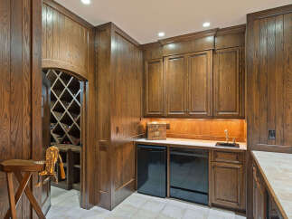 Discover this exquisite wine cellar featuring rich, dark wood paneling and a diamond-patterned wine rack, perfect for showcasing your collection.