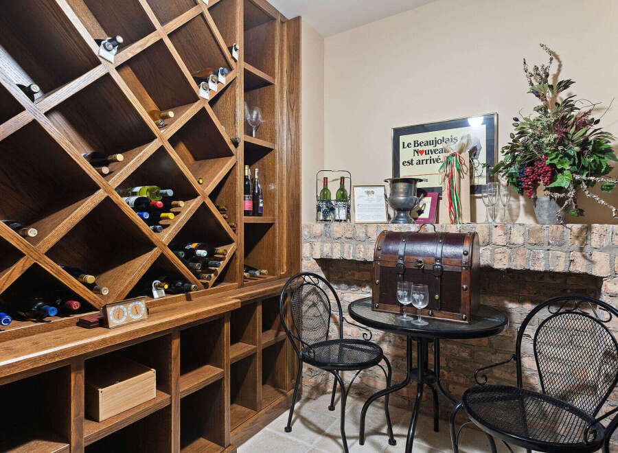 Discover this exquisite wine cellar, featuring a custom-built wooden wine rack with diamond-shaped compartments, perfect for storing your prized collection.