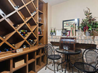 Discover this exquisite wine cellar, featuring a custom-built wooden wine rack with diamond-shaped compartments, perfect for storing your prized collection.