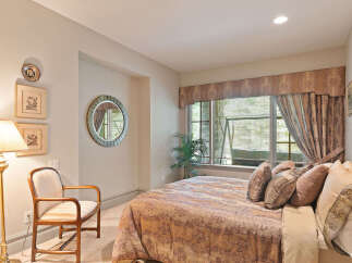 This inviting bedroom features a plush king-sized bed adorned with decorative pillows, perfect for a restful night's sleep.