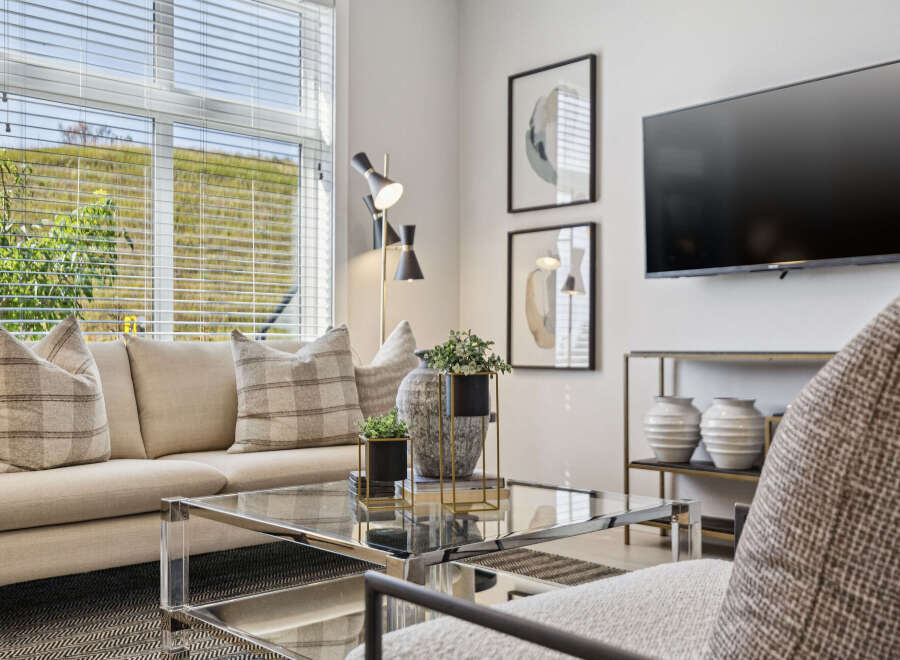 Experience modern living in this stylish living room, featuring a comfortable neutral-toned sofa adorned with plaid accent pillows.