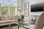 Experience modern living in this stylish living room, featuring a comfortable neutral-toned sofa adorned with plaid accent pillows.