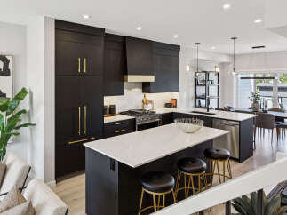 Experience modern luxury in this stunning kitchen featuring sleek black cabinetry with elegant gold hardware.
