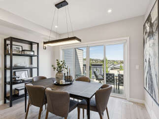 Experience elegant dining in this beautifully appointed space, featuring a sleek dark dining table complemented by plush upholstered chairs.