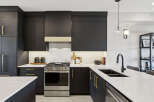 Experience modern luxury in this stunning kitchen, featuring sleek dark cabinetry complemented by elegant gold hardware.