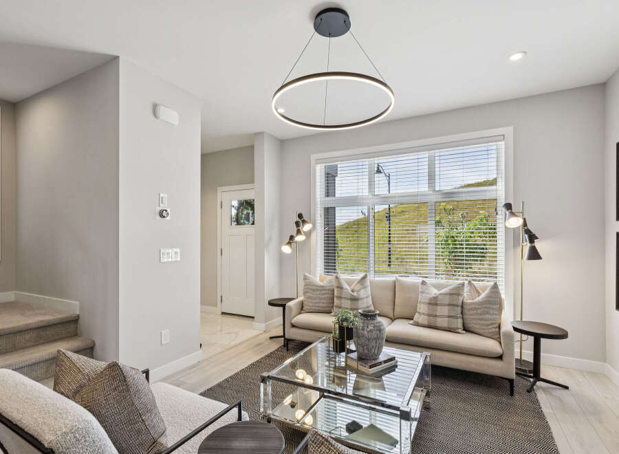 Step into this beautifully appointed living room, featuring a plush sofa adorned with tasteful throw pillows and a modern glass coffee table.