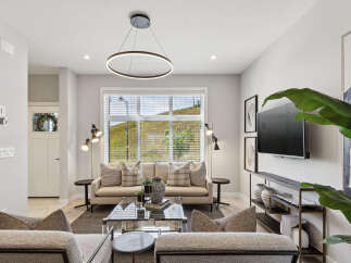 Experience modern living in this beautifully appointed living room, featuring a sleek circular pendant light and a large window offering scenic views.