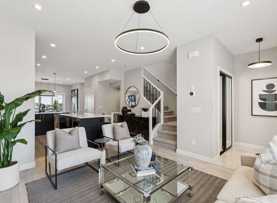 Experience modern living in this stunning open-concept home, featuring a sleek kitchen with a large island and elegant cabinetry.