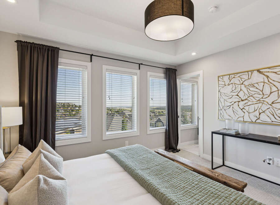 Experience luxury in this master bedroom, featuring a stunning tray ceiling and large windows that flood the space with natural light.