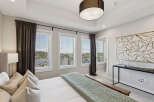 Experience luxury in this master bedroom, featuring a stunning tray ceiling and large windows that flood the space with natural light.