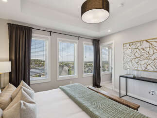 Experience luxury in this master bedroom, featuring a stunning tray ceiling and large windows that flood the space with natural light.