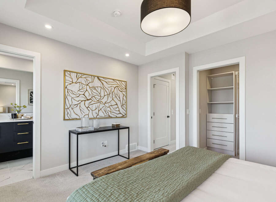 Experience modern comfort in this beautifully appointed bedroom, featuring a stylish console table with abstract art and a rustic wooden bench.