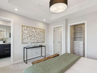 Experience modern comfort in this beautifully appointed bedroom, featuring a stylish console table with abstract art and a rustic wooden bench.