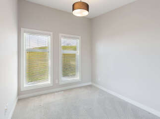 This bright and airy room features two large windows that flood the space with natural light, offering scenic views of the surrounding landscape.