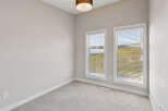 This empty room features neutral gray carpeting and walls, creating a blank canvas for your personal style.