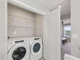 Discover convenient in-suite laundry with this modern Whirlpool washer and dryer set, neatly tucked away in a spacious closet.