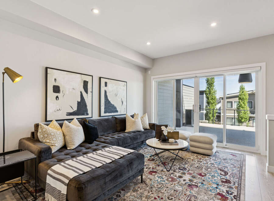 Experience modern living in this stylish living room, featuring a plush charcoal sectional sofa adorned with decorative pillows and a cozy throw.