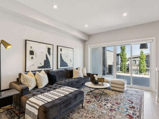 Experience modern living in this stylish living room, featuring a plush charcoal sectional sofa adorned with decorative pillows and a cozy throw.