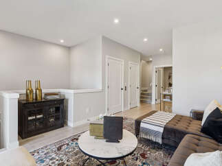 Step into this inviting living space, featuring a plush sectional sofa adorned with decorative pillows and a cozy throw.