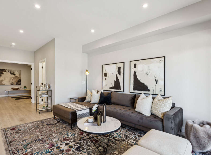 Step into this elegantly designed living room, featuring a plush tufted sectional sofa perfect for relaxation and entertaining.