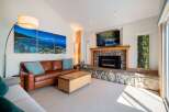 Experience luxury living in this stunning living room, featuring a cozy stone fireplace and a large flat-screen TV perfect for entertainment.