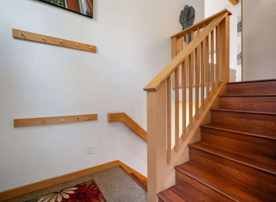 Ascend to the upper levels of this stunning home via a beautifully crafted wooden staircase, featuring rich, dark wood treads and a light wood banister.