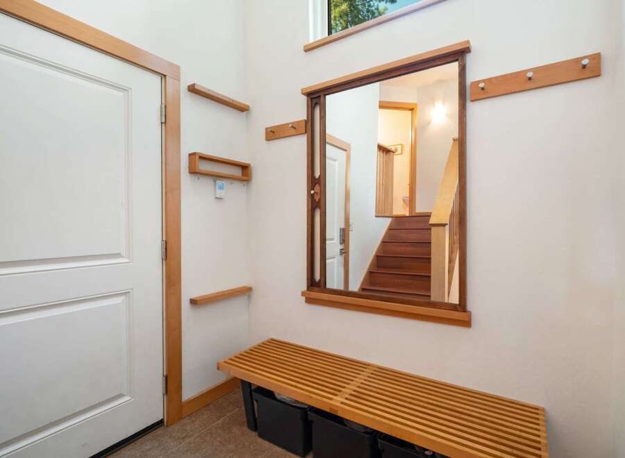 This entryway features a modern design with a sleek white door framed by warm wood accents.