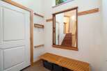 This entryway features a modern design with a sleek white door framed by warm wood accents.